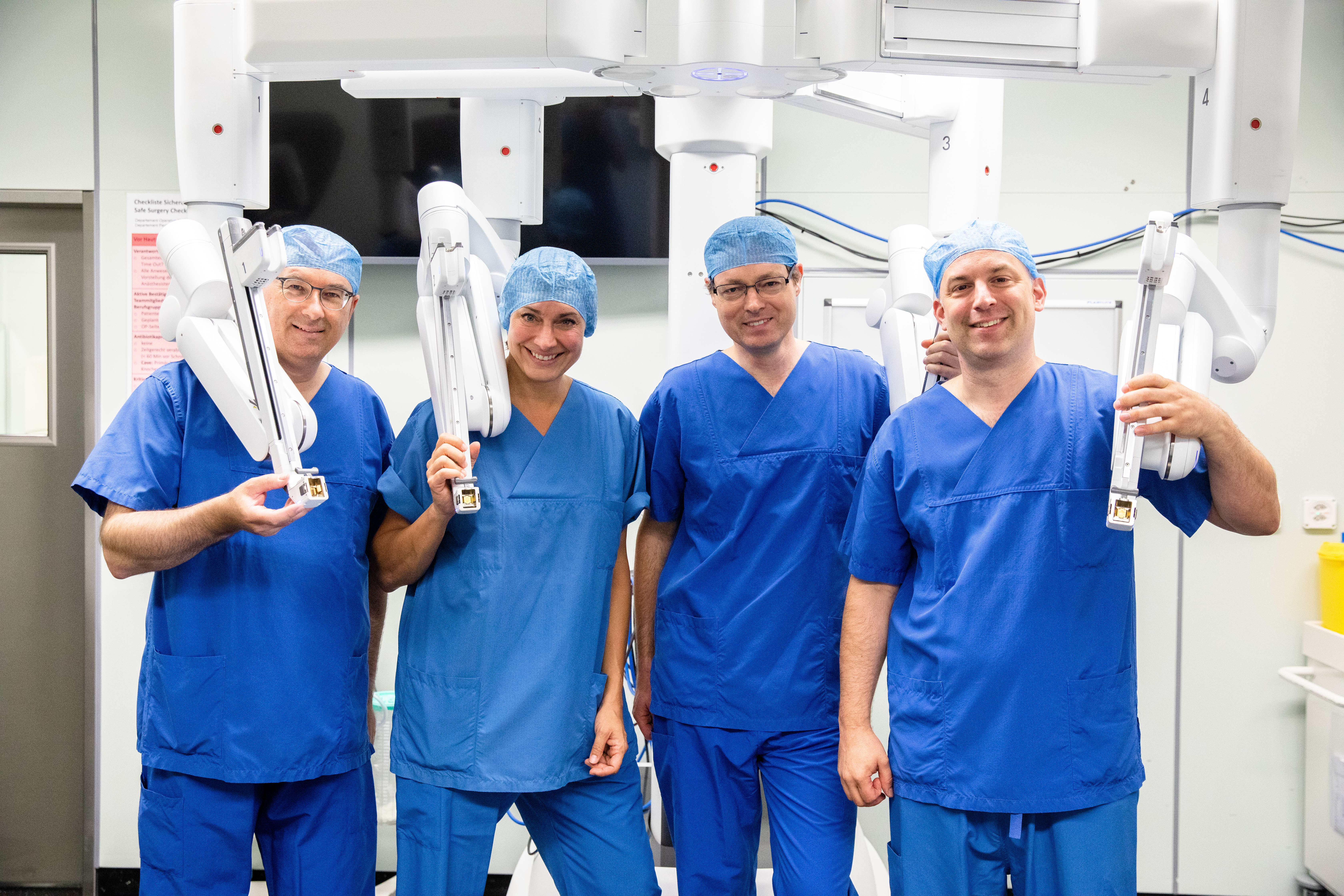 Vier Chirurginnen und Chirurgen vor dem Da Vinci