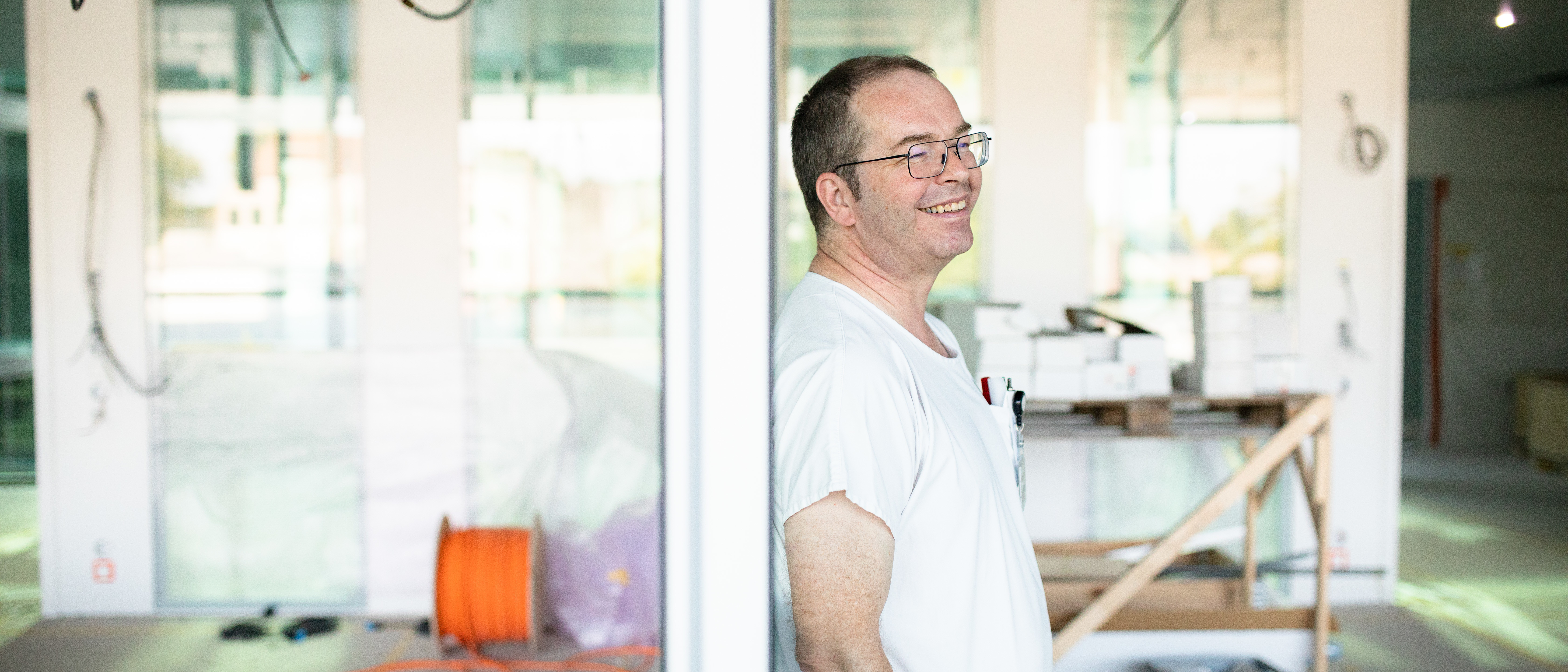 Lukas Ebnöther lehnt an einer Türe im Neubau